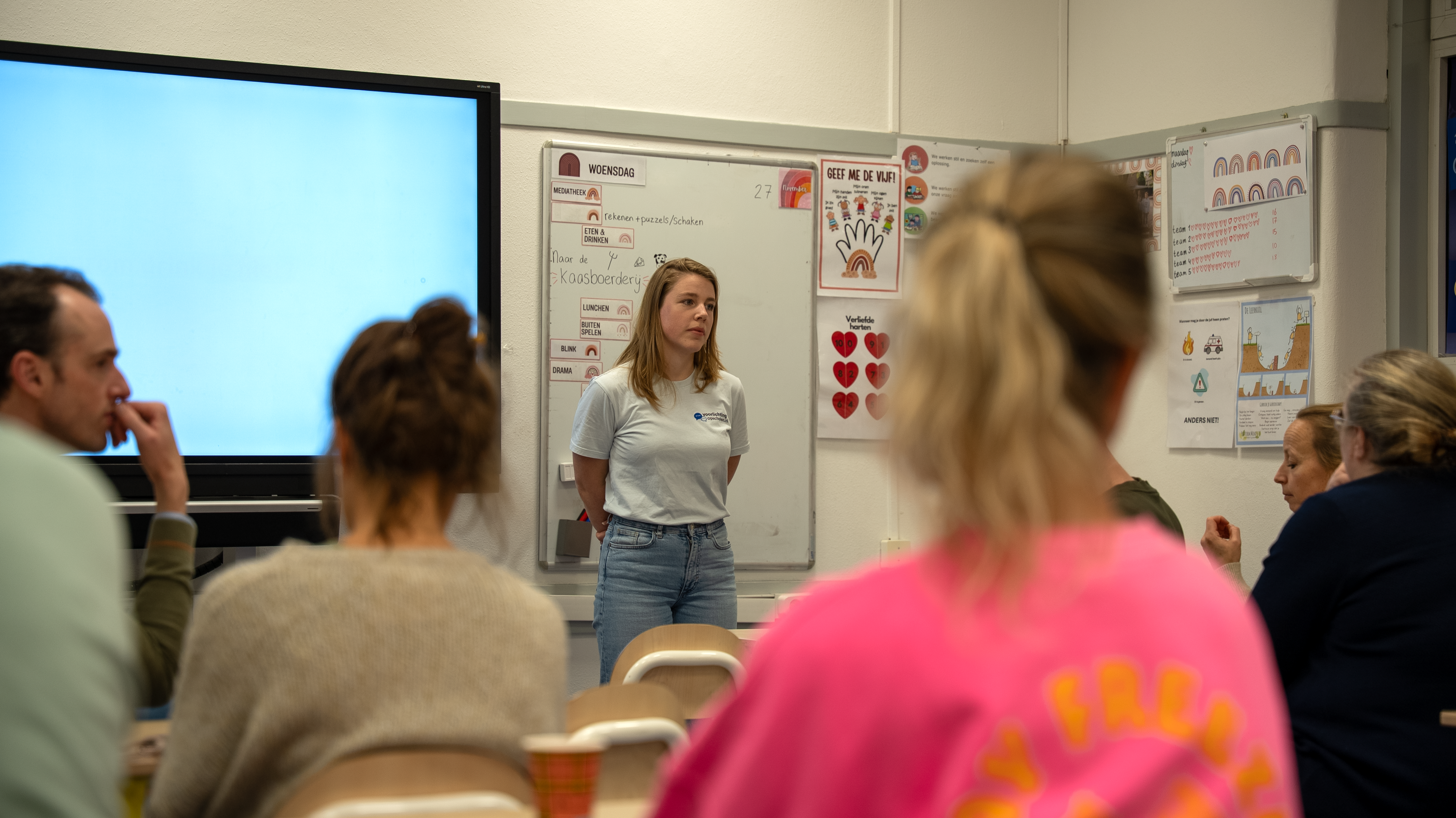 Voorlichter van Voorlichting op Scholen spreekt tijdens een sessie over respect en empathie in de klas, met aandachtige volwassenen als publiek.