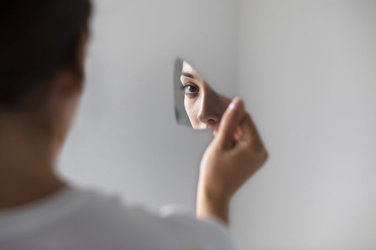 Jongere kijkt in gebroken spiegel als metafoor voor zelfbeeld onder invloed van looksmaxing op sociale media