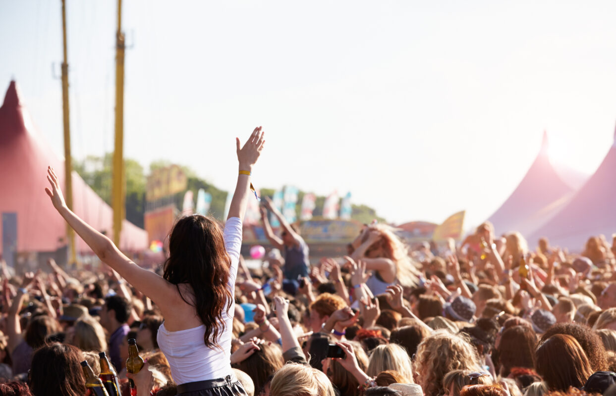 Jongeren feesten op een druk festival met handen in de lucht, symbool voor de normalisatie van drugsgebruik in de uitgaanscultuur.