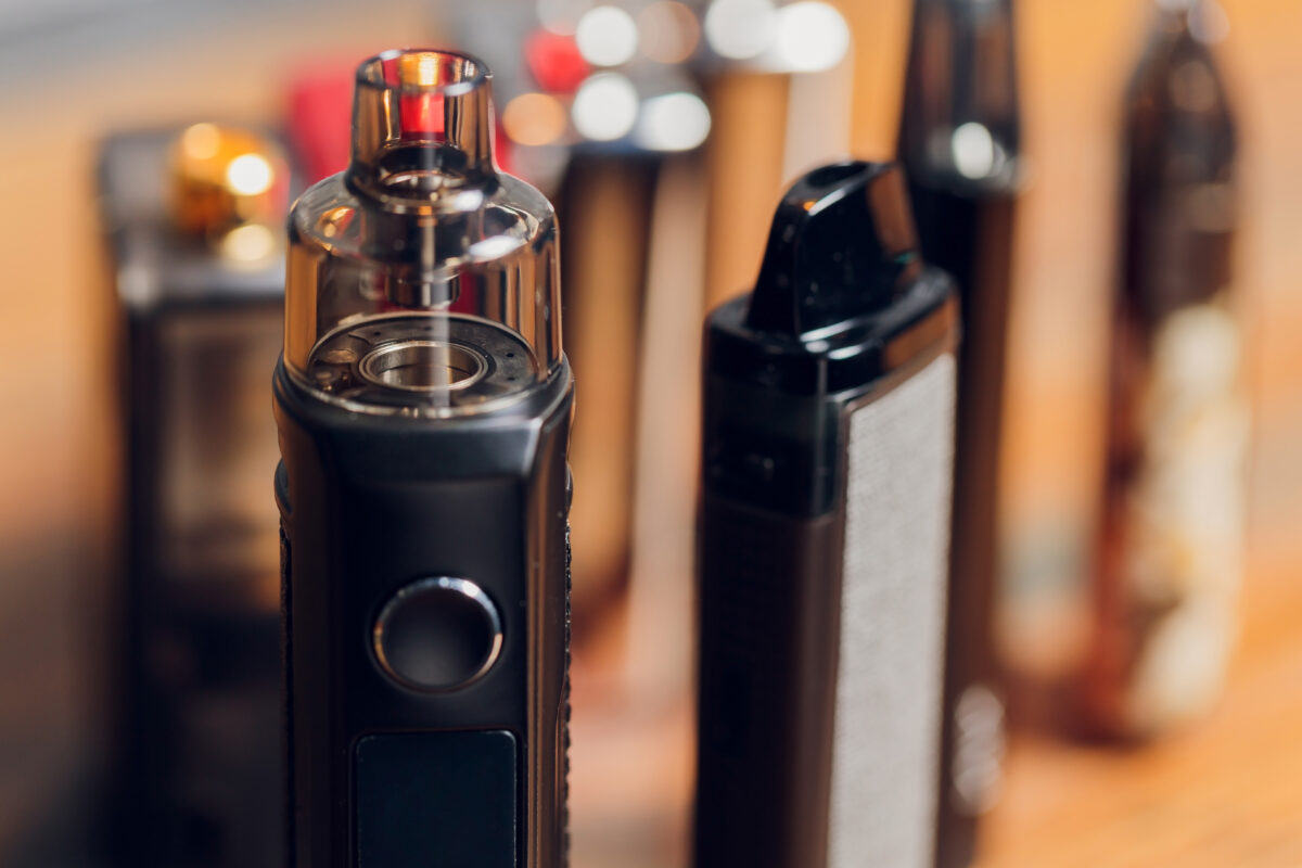 Close-up van verschillende moderne vape-apparaten, vergelijkbaar met THC-vapes die populair zijn onder jongeren.