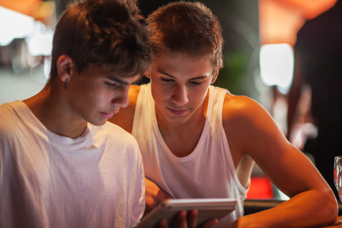 Twee jongeren kijken samen naar een tablet terwijl ze online antwoorden zoeken op persoonlijke vragen.