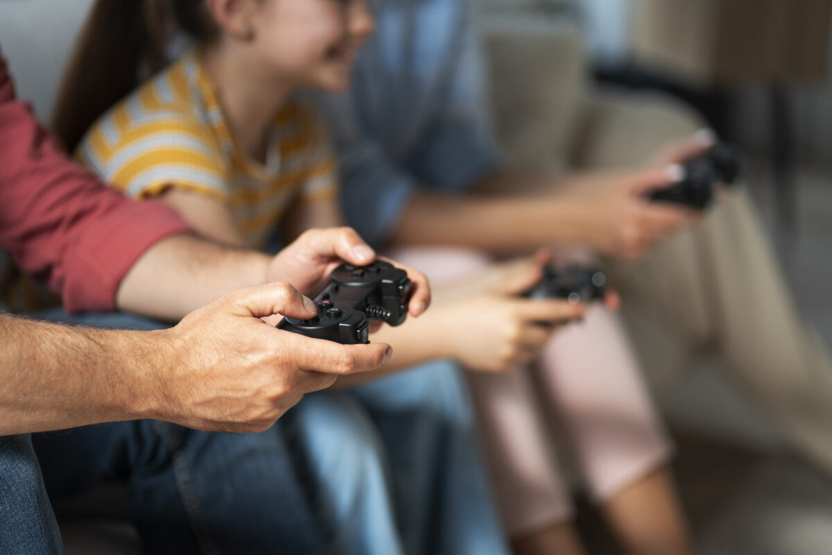 Kind en ouder spelen samen een videogame op de bank