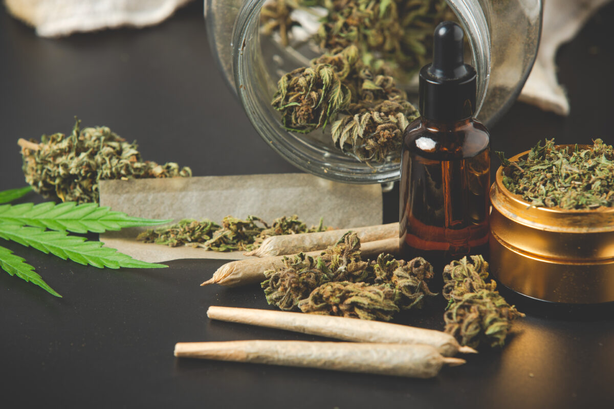Cannabisproducten zoals joints, wiettoppen en cannabisolie op tafel, die laten zien hoe divers en laagdrempelig cannabisgebruik tegenwoordig is.