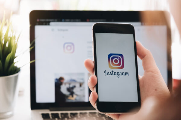 Smartphone met Instagram-app in beeld, symbool voor sociale media waar haatdragende reacties onder AI-satire zichtbaar worden