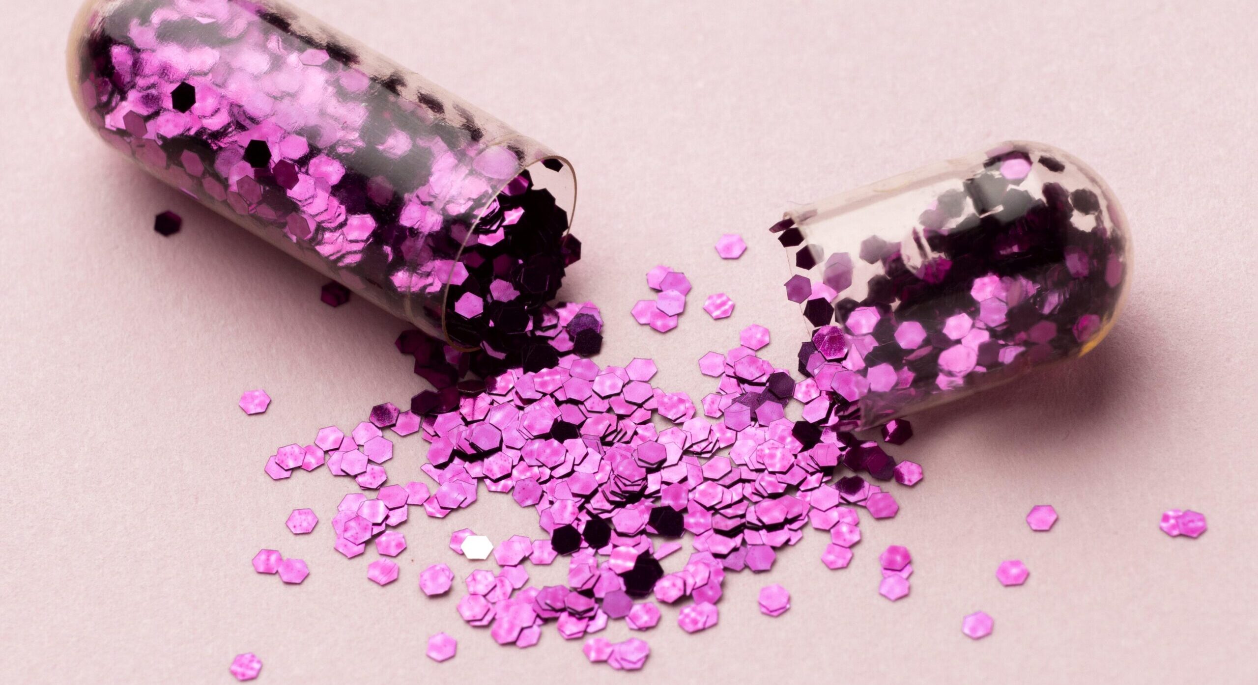 Open capsule met roze glinsterende inhoud, gebruikt als illustratie bij uitleg over Tusi of roze cocaïne