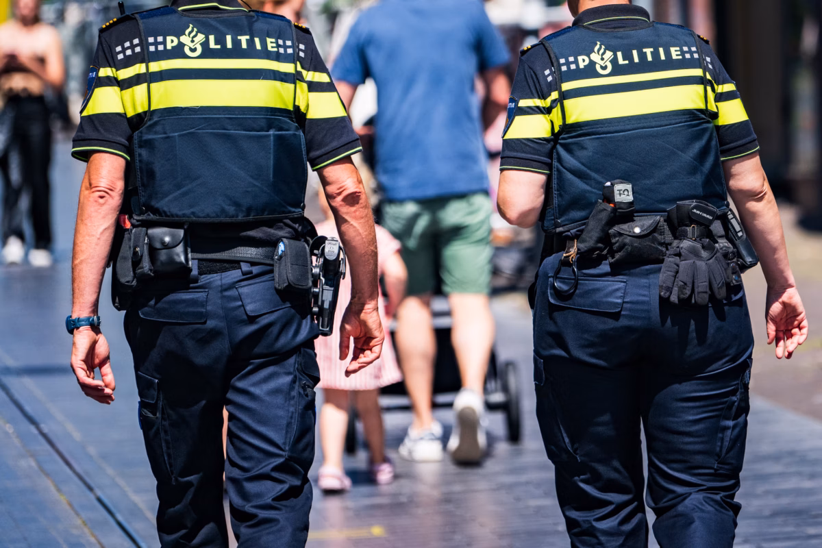 Politieagenten in gesprek op straat tijdens toezicht, symbool voor veranderende criminaliteit en jongeren die vaker betrokken raken.