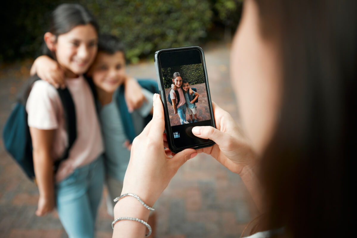 Moeder maakt foto van haar kinderen met smartphone als voorbeeld van kinderen online plaatsen en sociale media trends