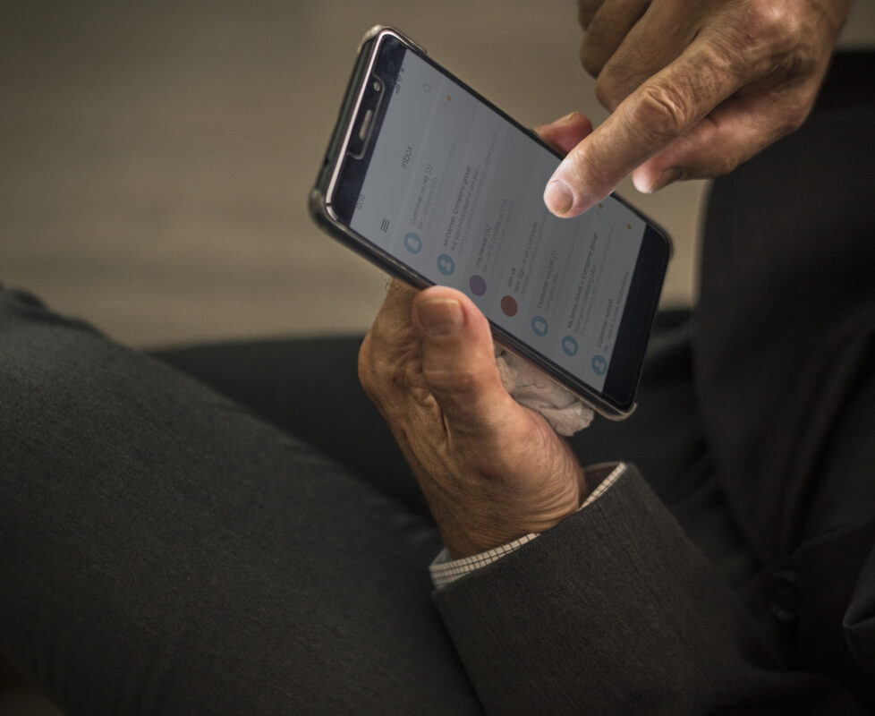 Man bekijkt berichten op een smartphone terwijl hij door een inbox op zijn telefoon scrolt
