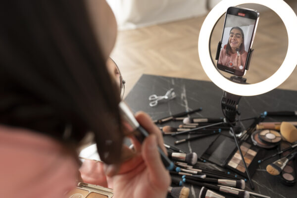 Jongere maakt een make-up video met smartphone en ringlamp voor social media