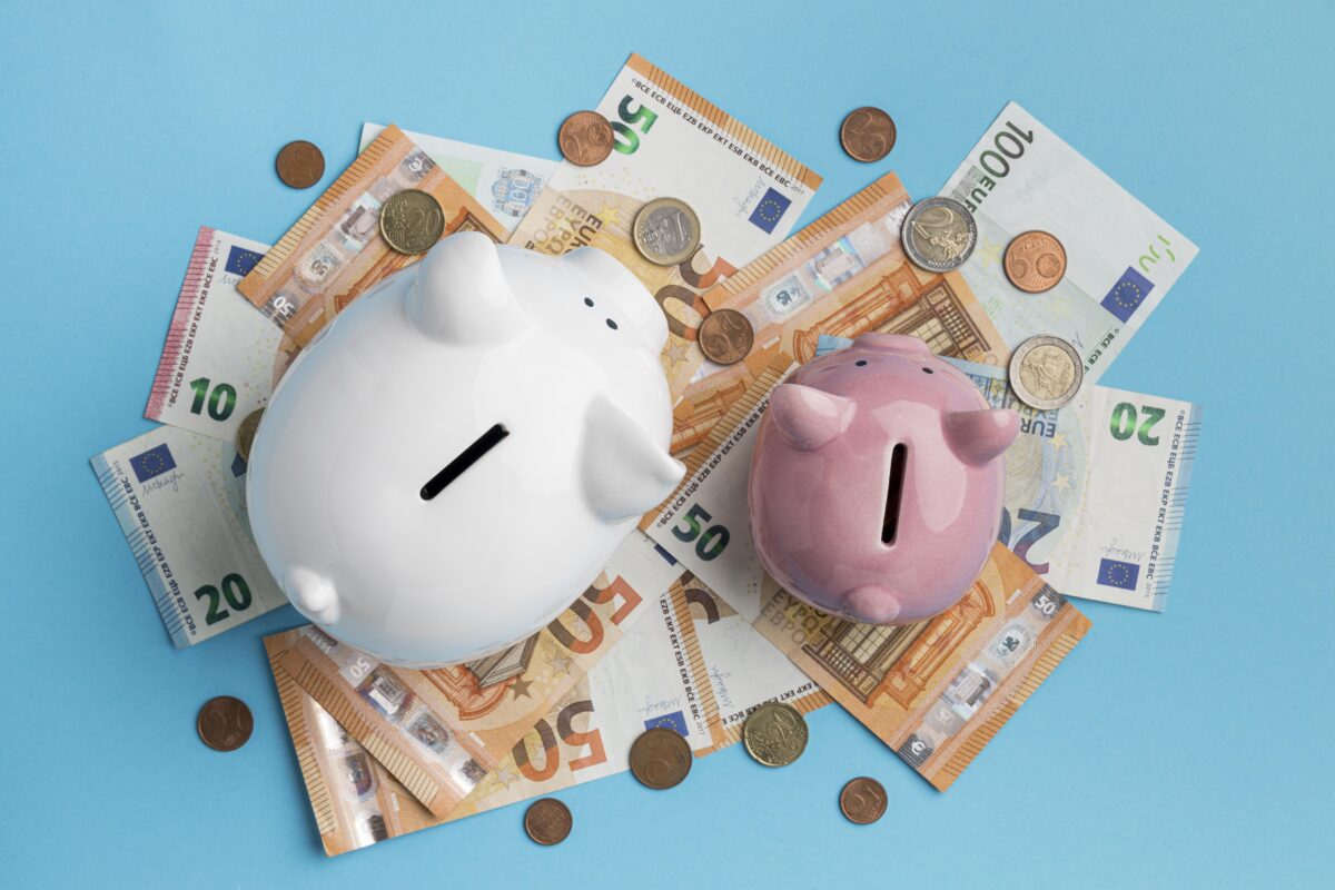 Twee spaarvarkens op eurobiljetten en muntgeld, als symbool voor sparen, financiële planning en geldzaken bij jongeren.