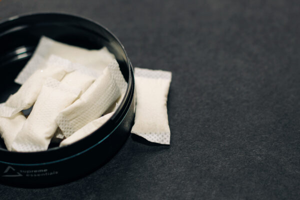 Blikje met nicotinezakjes zonder tabak, gebruikt ter illustratie van het verschil tussen snus en nicotinezakjes.