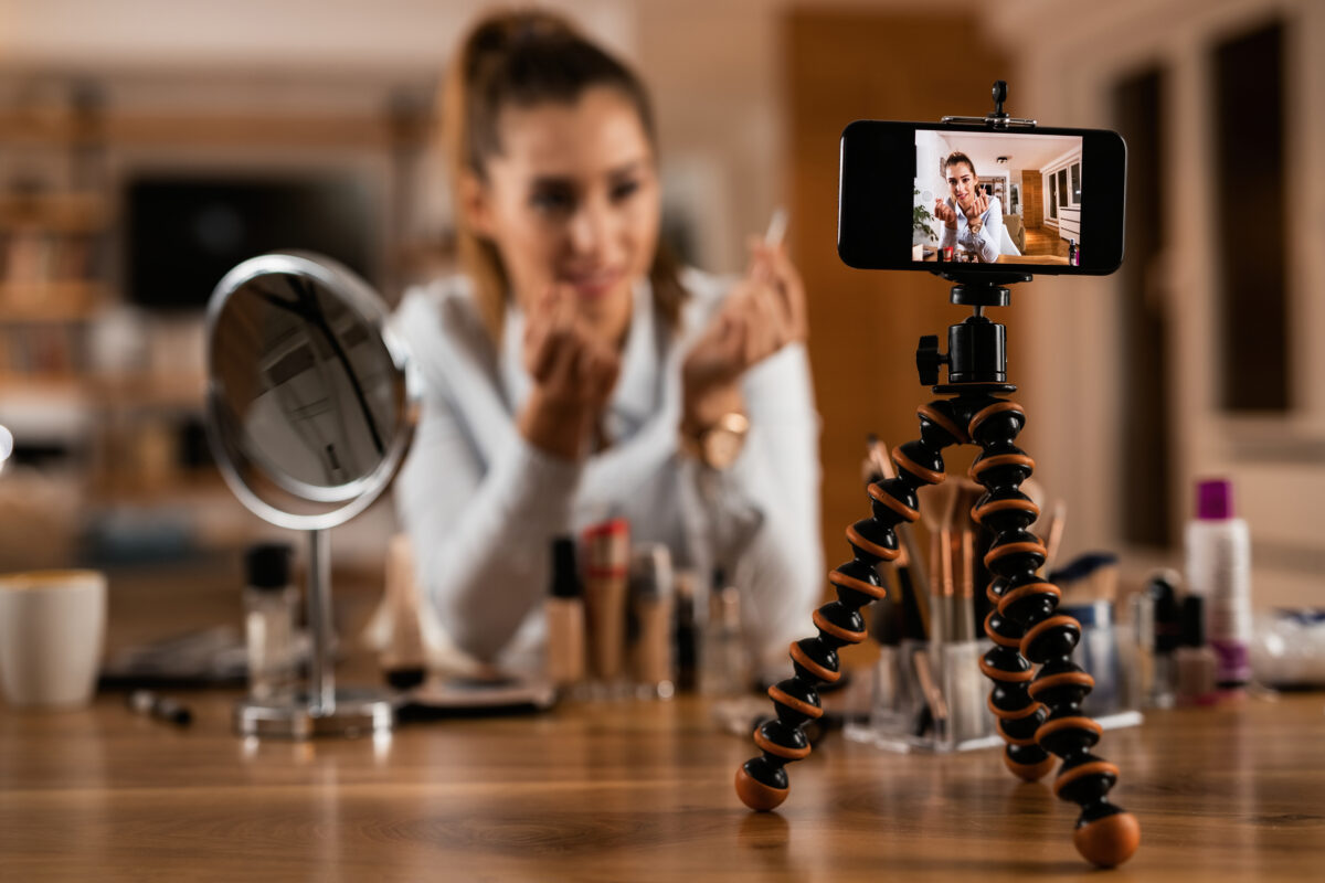 Influencer neemt een video op waarin zij een beautyproduct bespreekt voor haar volgers op sociale media.