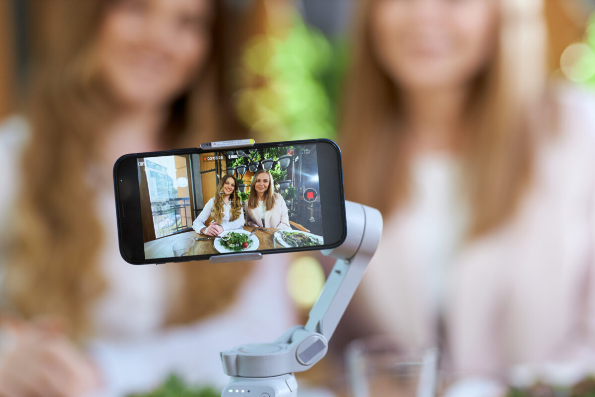 Twee jonge vrouwen maken een livestream met een smartphone
