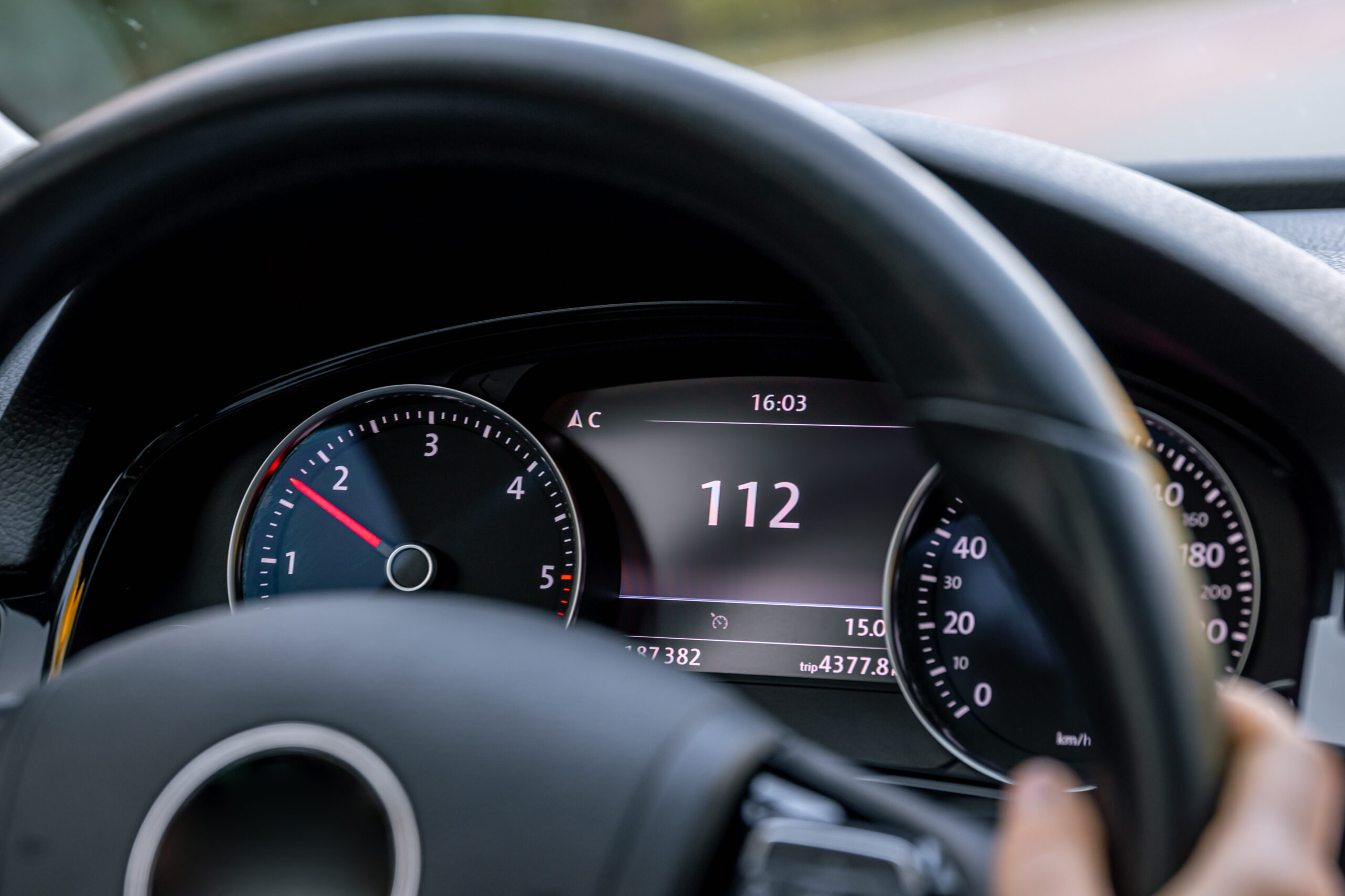 Bestuurder rijdt 112 km/u terwijl het dashboard en stuur van de auto zichtbaar zijn.