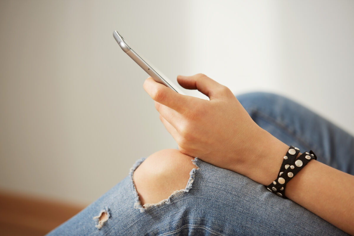 Jongere met smartphone in de hand, passend bij een blog over gezondheidswaarschuwingen op sociale media.
