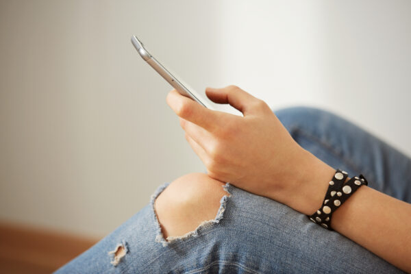 Jongere met smartphone in de hand, passend bij een blog over gezondheidswaarschuwingen op sociale media.