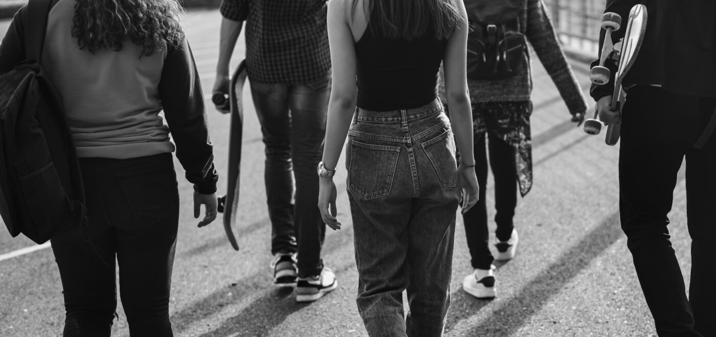Groep jongeren loopt samen over straat, passend bij een blog over online seksuele intimidatie binnen vriendengroepen.