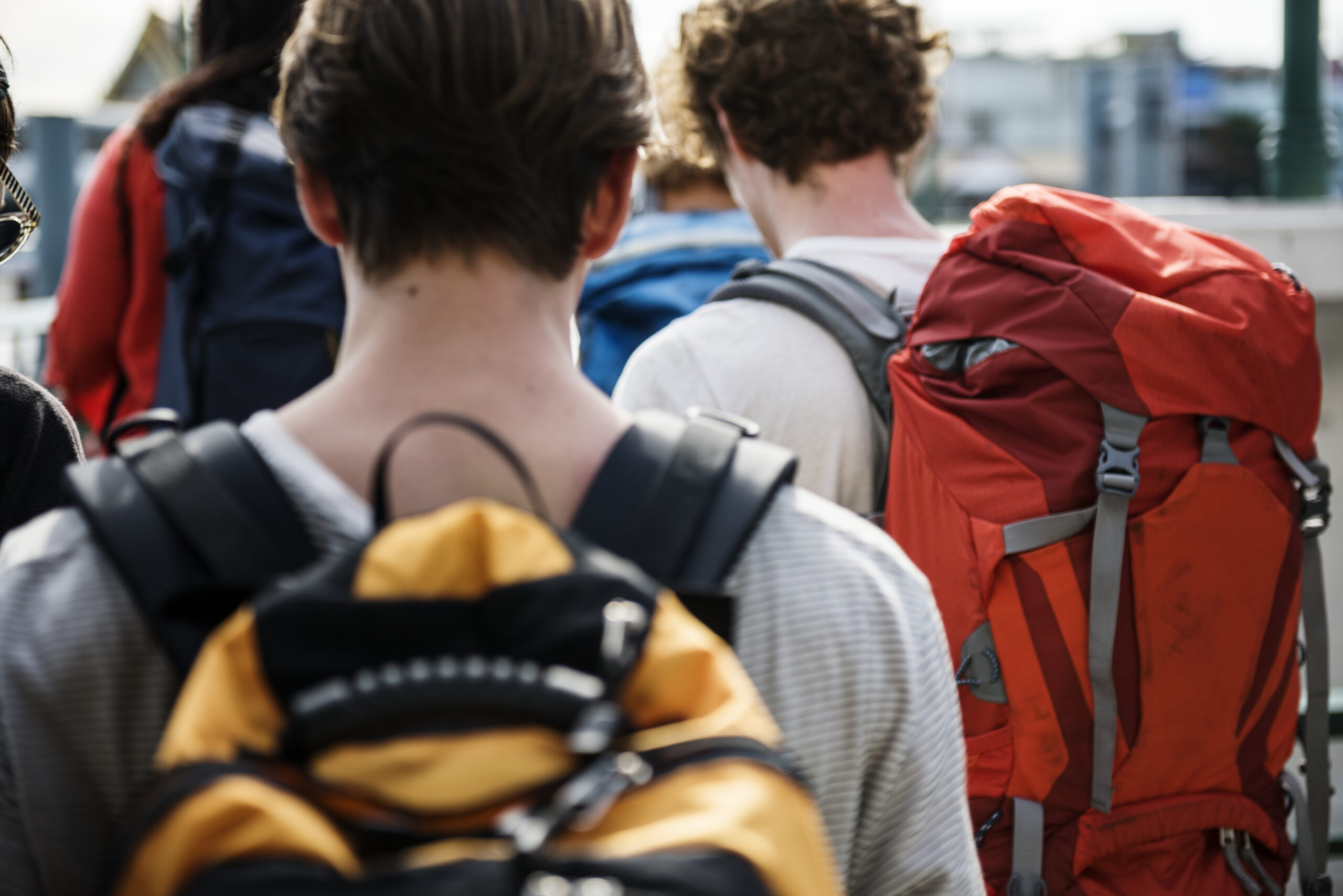 Groep jonge backpackers met grote rugzakken op reis, passend bij de micro-retirementtrend waarbij jongeren tijdelijk stoppen met werken.