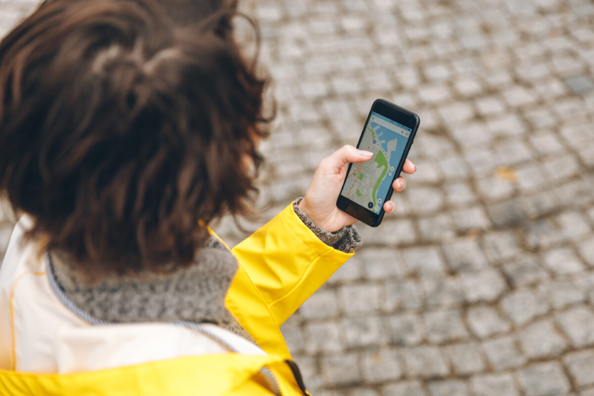 Jongere bekijkt een digitale kaart op haar smartphone om haar locatie te bekijken.