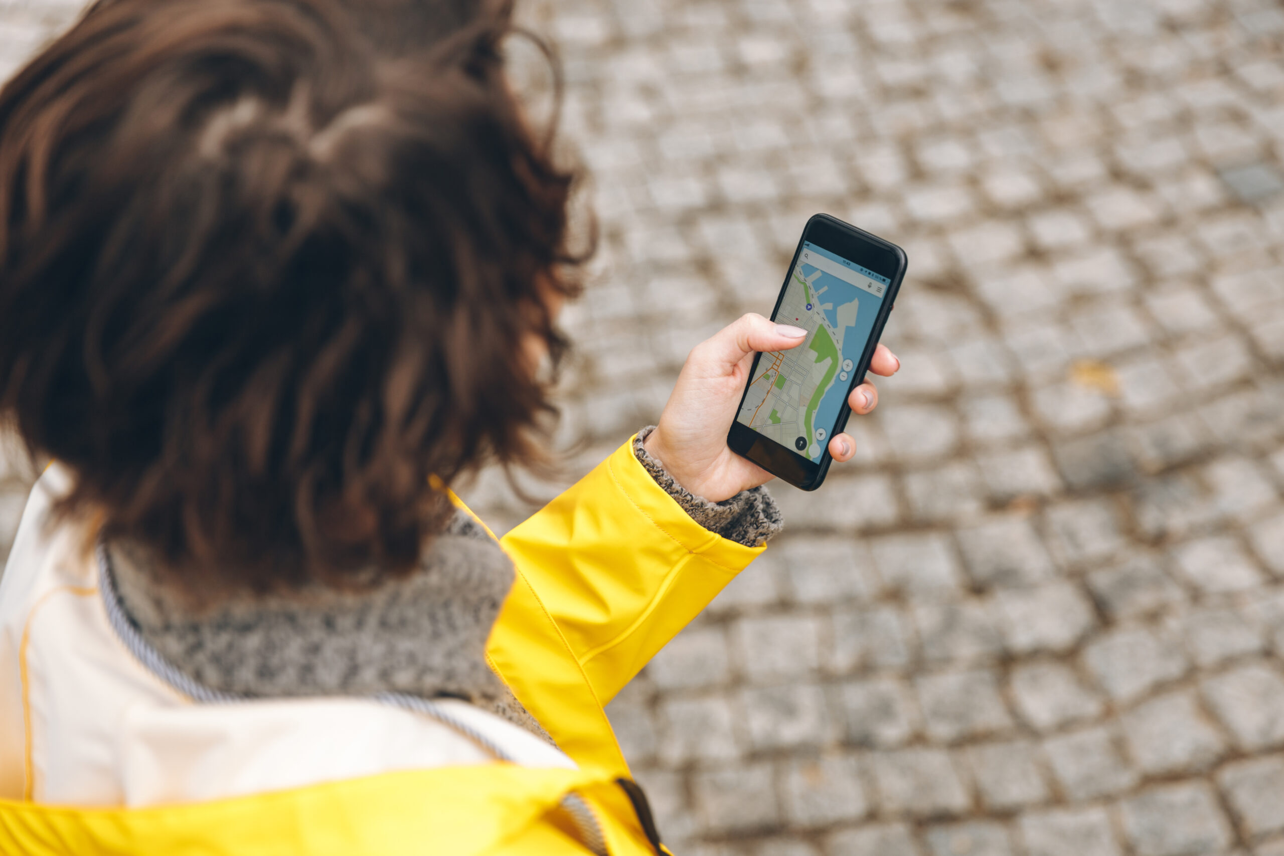 Jongere bekijkt een digitale kaart op haar smartphone om haar locatie te bekijken.